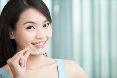 patient holding her new ClearCorrect aligners