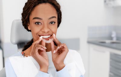 patient holding her new Invisalign clear aligners