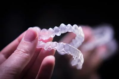 patient holding their new Invisalign clear aligners