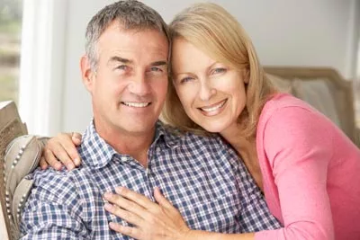 man with dental implants smiling with his wife